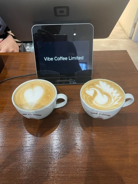 Vibe Coffee latte art cups on wooden table